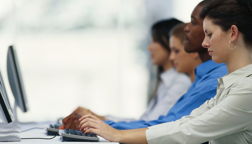 Four business executives using computer in office, side view
