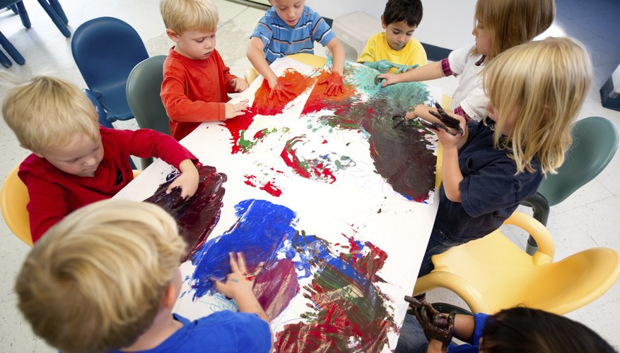 A group of young children fingerpaint A group of young children fingerpaint