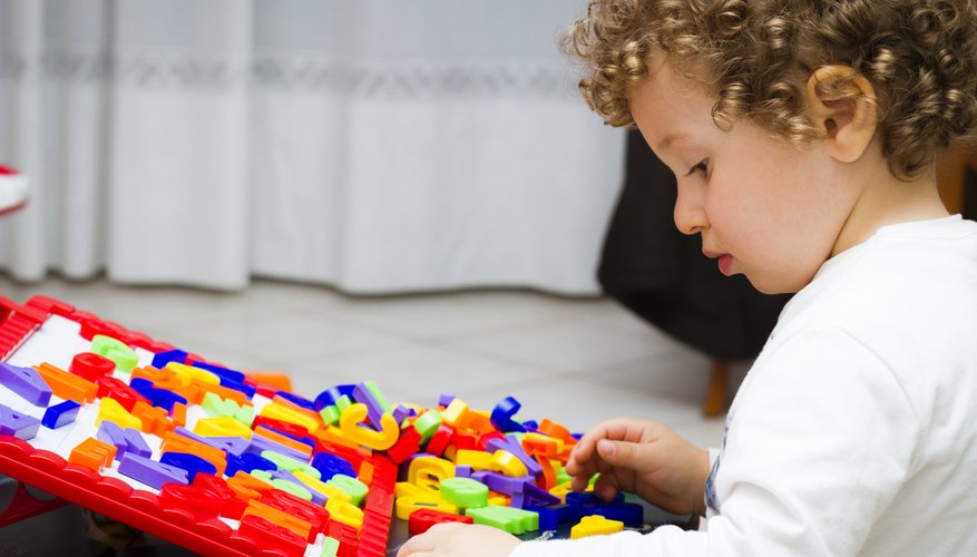A toddler plays with toy letters A toddler plays with toy letters