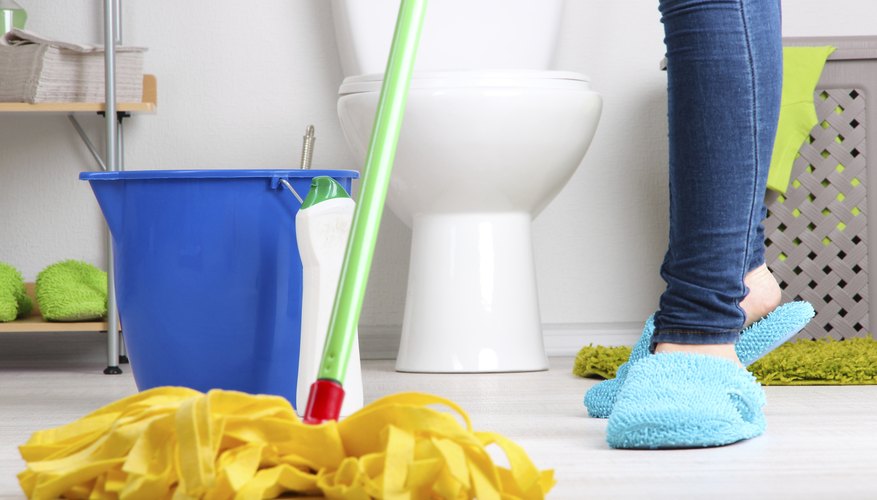 Photo Credit: serezniy/iStock/Getty Images A woman mops a bathroom floor.