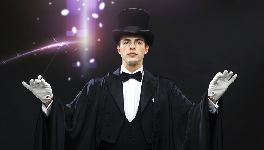 magician in top hat with magic wand showing trick