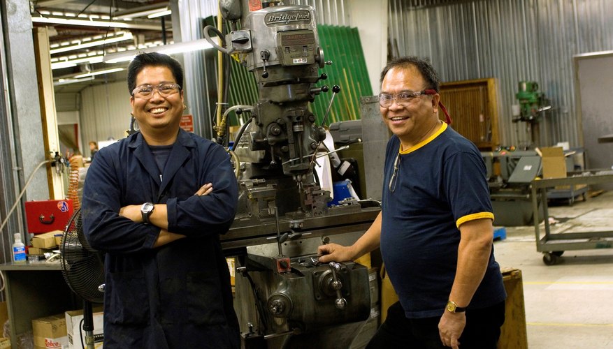Portrait of Asian machinists in work shop.
