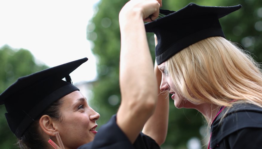 Two college graduates getting ready for commencements.