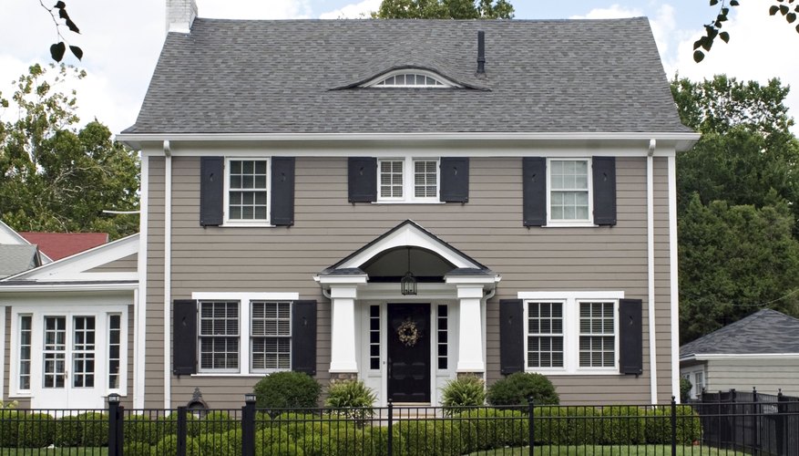 A light gray home with a dark gray door and shutters. A light gray home with a dark gray door and shutters.