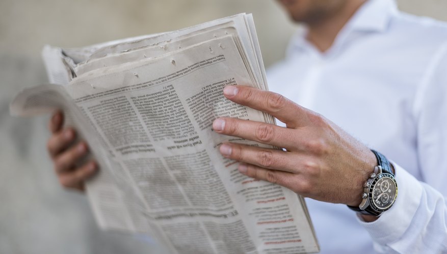 Hombre leyendo anuncios de periódicos