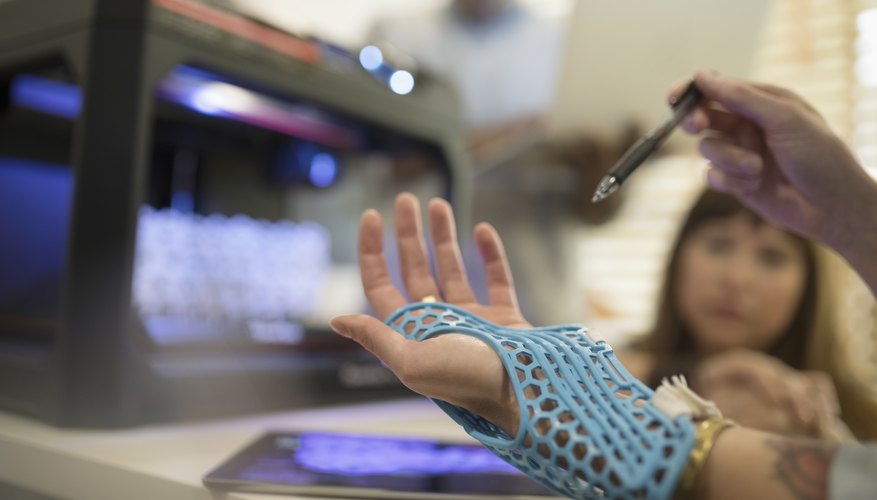 Close up designer trying on prototype glove at 3D printer
