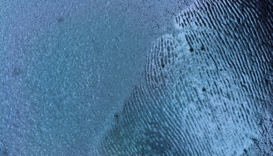 Photo Credit: Hemera Technologies/AbleStock.com/Getty Images White fingerprint dust is used on dark surfaces.