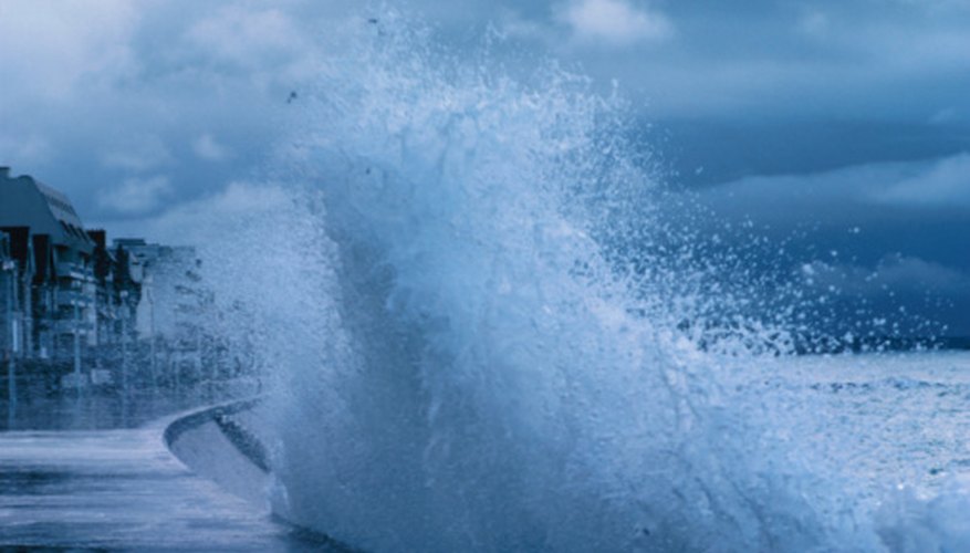 Photo Credit: Hemera Technologies/Photos.com/Getty Images A wave hitting a curved seawall.