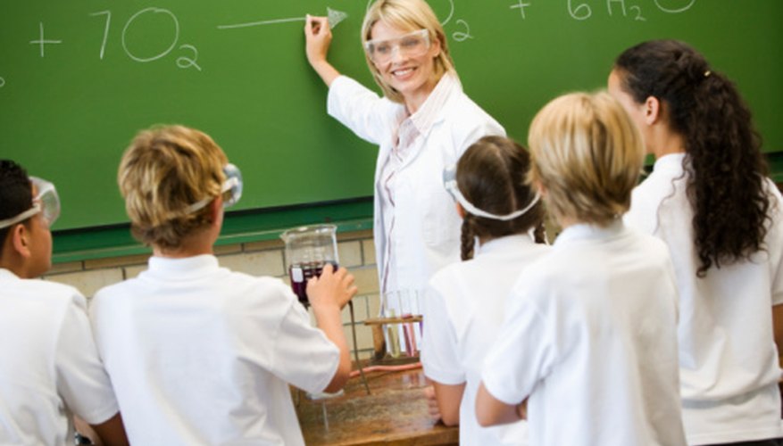 Photo Credit: BananaStock/BananaStock/Getty Images The teacher writes the neutralization equation with water as the product.