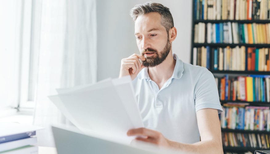 man with a beard looking over documents