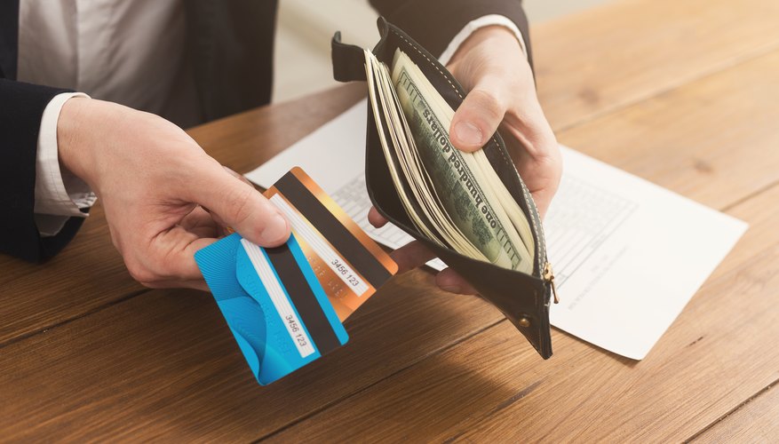 Man's hands holding open wallet with money