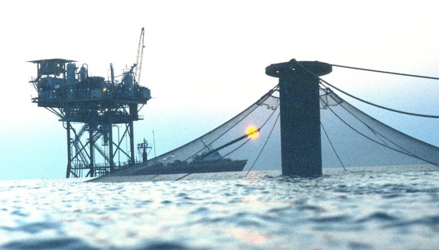 Covered salmon cage near an oil rig