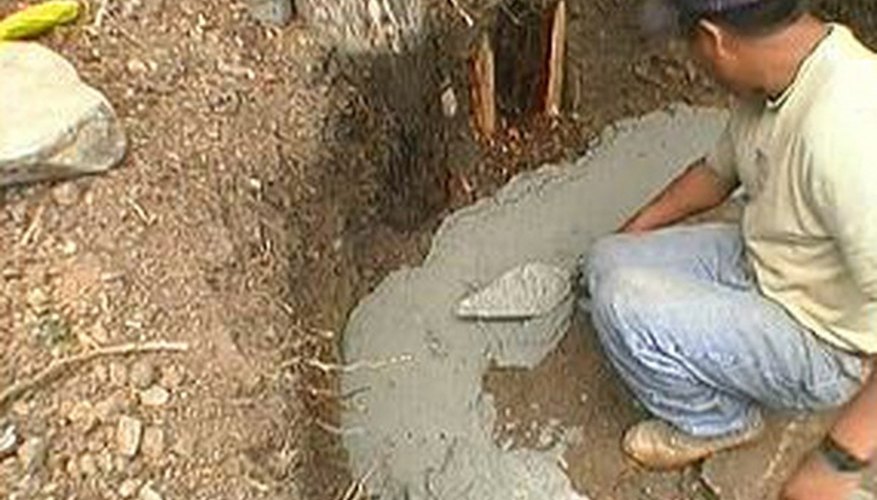 Mortar is spread into a trench for a curved bench. Mortar is spread into a trench for a curved bench.