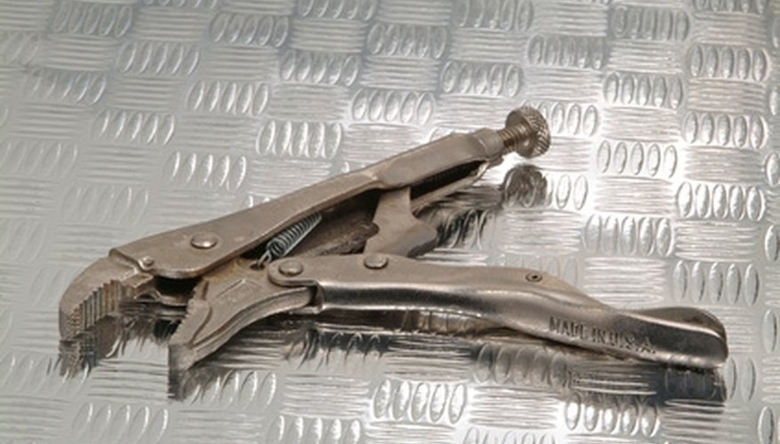 A vice grips holds the ornamental iron bar in place to allow for twisting. A vice grips holds the ornamental iron bar in place to allow for twisting.