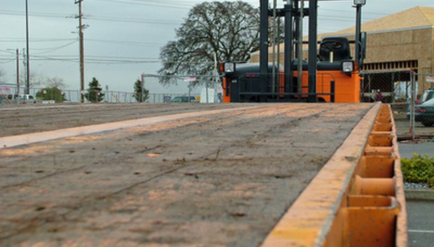 Flatbed truck with trailing forklift. Flatbed truck with trailing forklift.