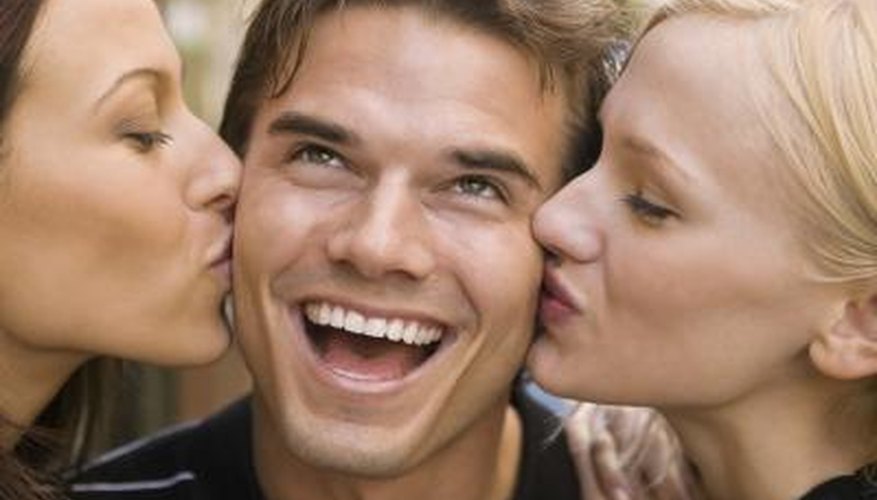 two woman giving a man playful kisses two woman giving a man playful kisses