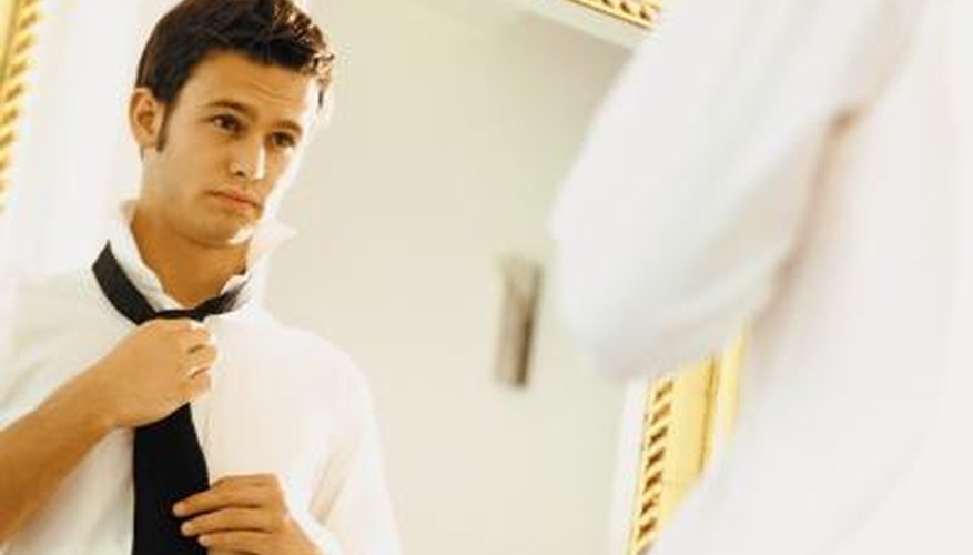 Man putting on tie Man putting on tie