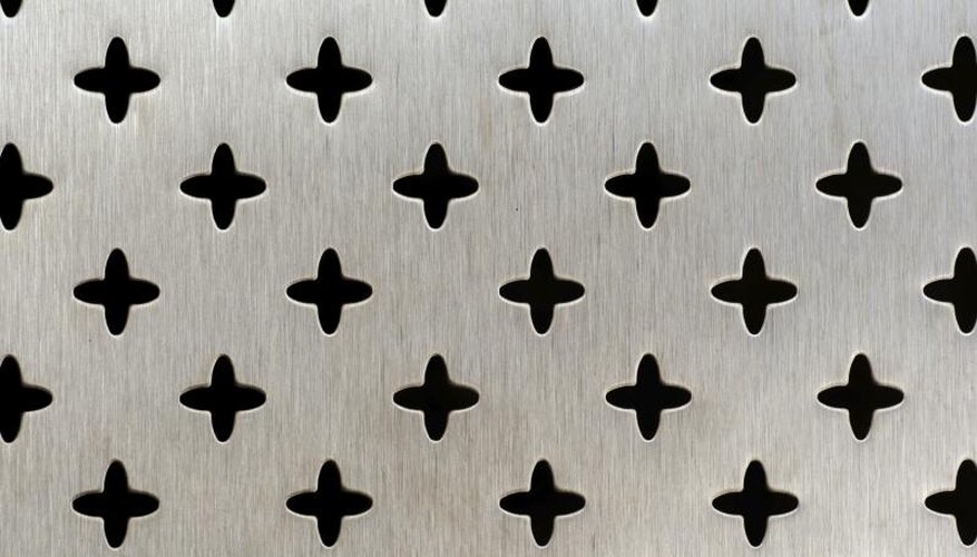 Close-up of a decorative perforated aluminum sheet, cut in a cross pattern. Close-up of a decorative perforated aluminum sheet, cut in a cross pattern.