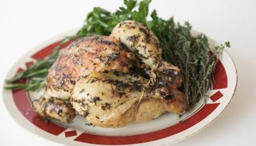 A roasted chicken with vegetables on a plate. A roasted chicken with vegetables on a plate.