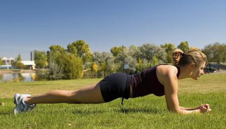 Woman holding the plank position outside. Woman holding the plank position outside.