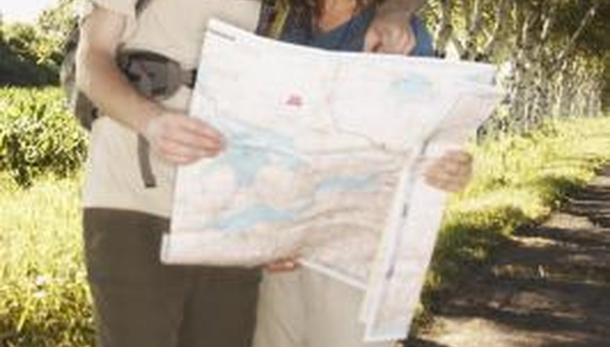 Couple looking at a map on hiking trail Couple looking at a map on hiking trail