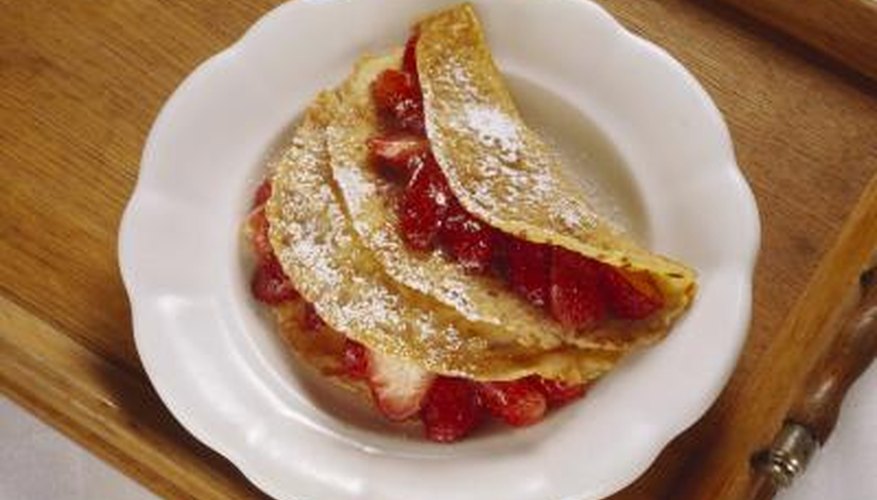 A strawberry-filled crepe is a simple and delicious dessert. A strawberry-filled crepe is a simple and delicious dessert.