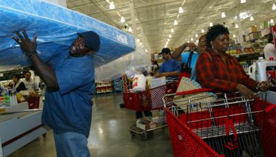 Man carrying a mattress out of a store Man carrying a mattress out of a store