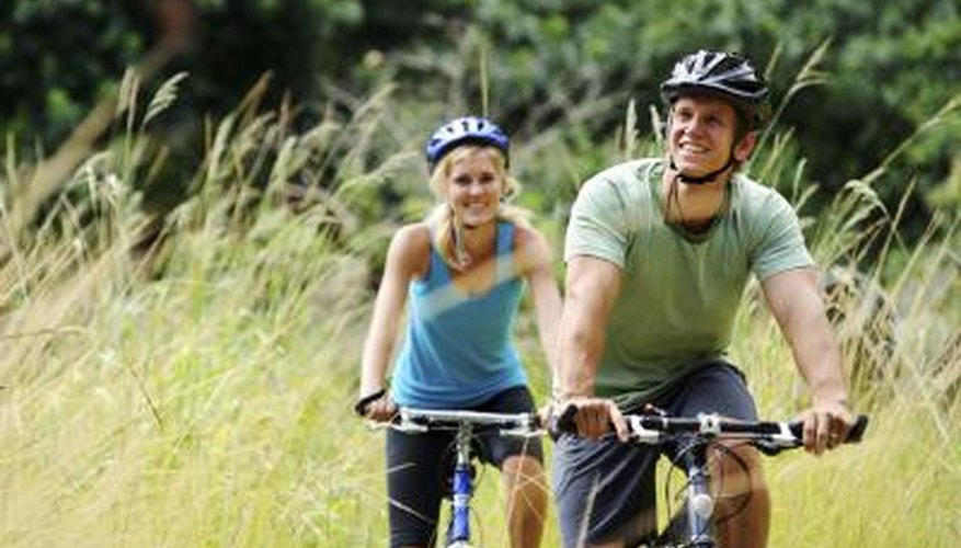 A couple enjoys mountain biking together outdoors. A couple enjoys mountain biking together outdoors.