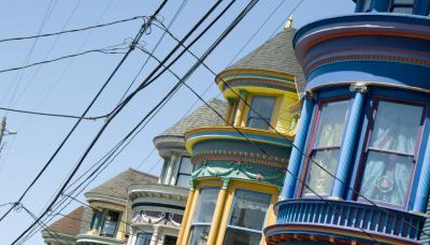 Cable car lines run by a blue Victorian with mauve trim around the windows. Cable car lines run by a blue Victorian with mauve trim around the windows.