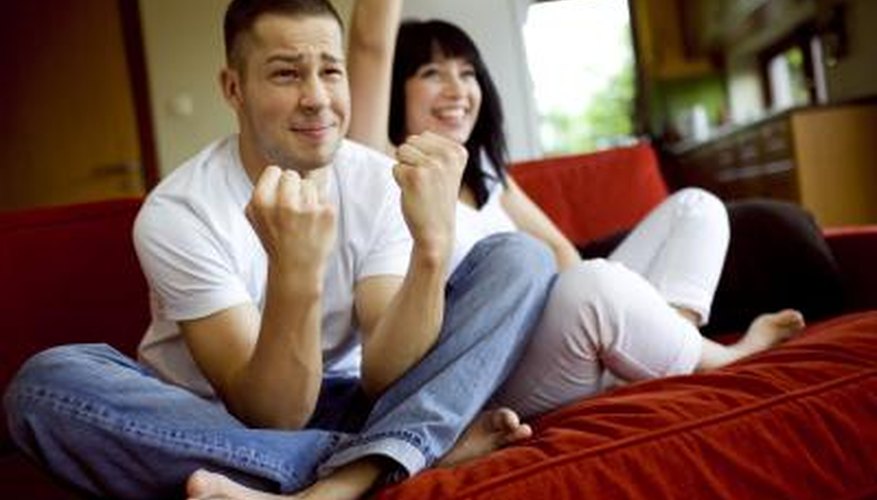 A couple watches a game on tv together. A couple watches a game on tv together.