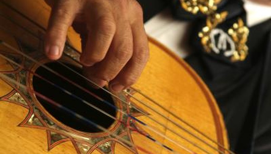 A close-up of a man playing a Spanish guitar. A close-up of a man playing a Spanish guitar.