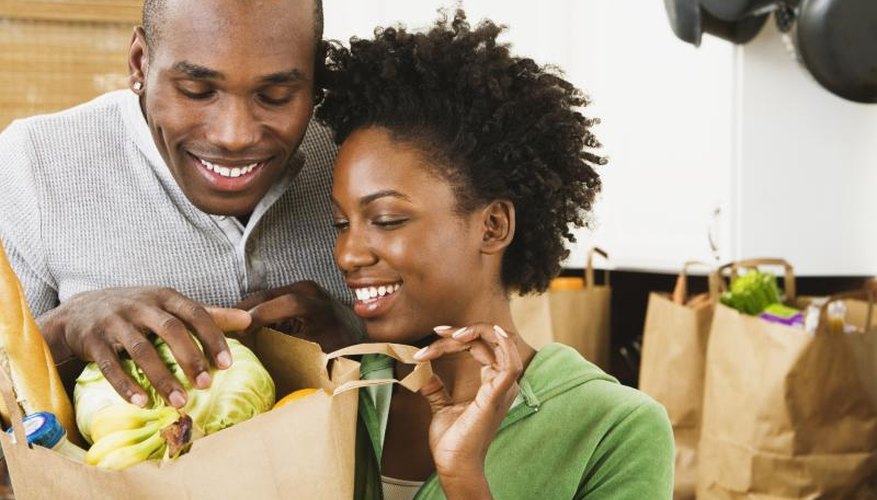 A couple is unloading healthy foods from grocery bags. A couple is unloading healthy foods from grocery bags.