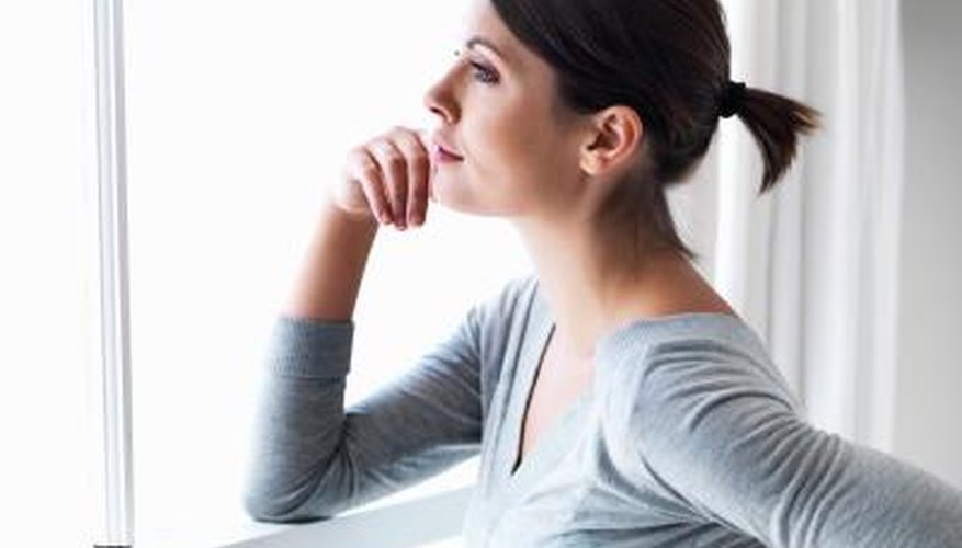 Woman thoughtfully looking out window Woman thoughtfully looking out window