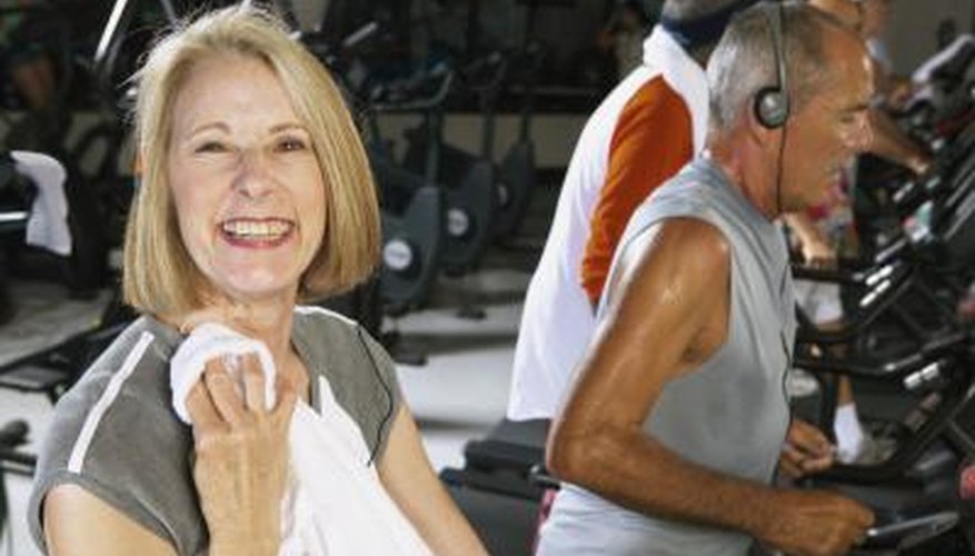 A mature woman is finishing up her workout on the treadmill. A mature woman is finishing up her workout on the treadmill.