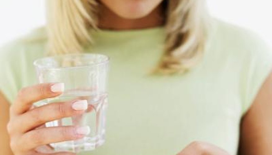 Close up of a woman with pills and a glass of water. Close up of a woman with pills and a glass of water.