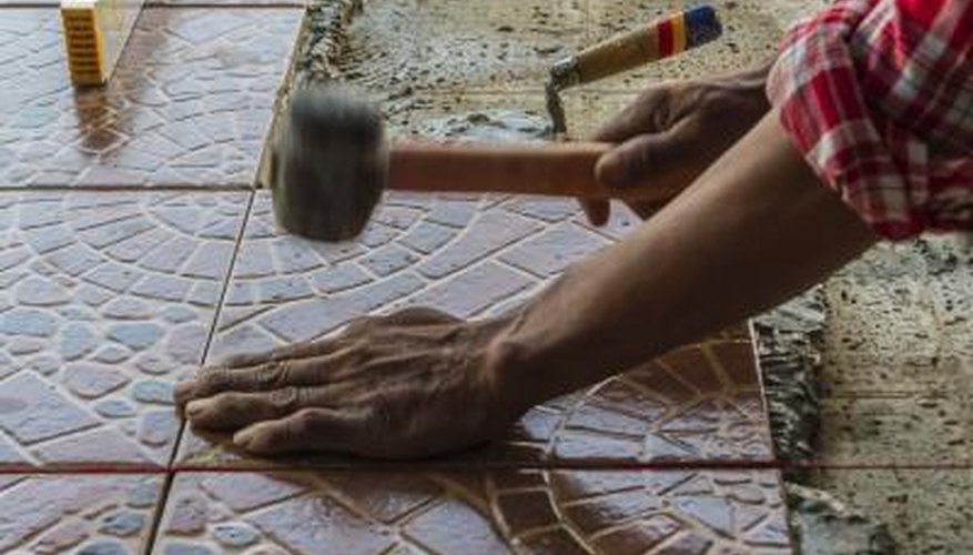 The installation of a mosaic floor using stone tiles. The installation of a mosaic floor using stone tiles.