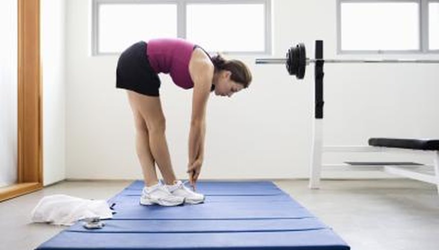 Young woman doing stretches on a mat at the gym. Young woman doing stretches on a mat at the gym.