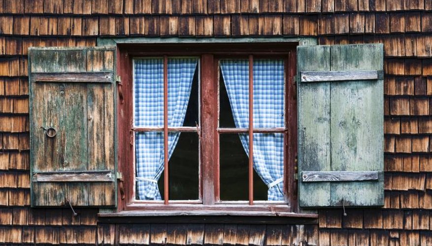A cottage window with blue gingham curtains. A cottage window with blue gingham curtains.