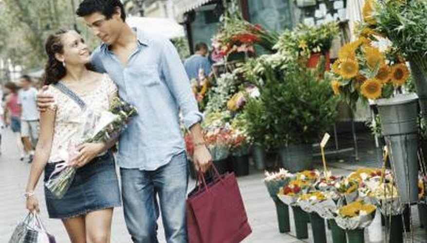 A young couple walks together with shopping bags and flowers. A young couple walks together with shopping bags and flowers.