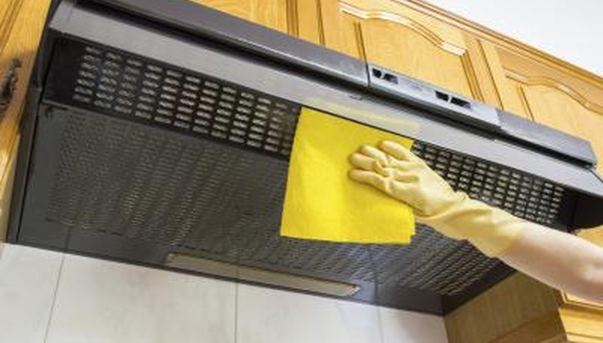 Ventilation hood for a gas stove top being cleaned. Ventilation hood for a gas stove top being cleaned.