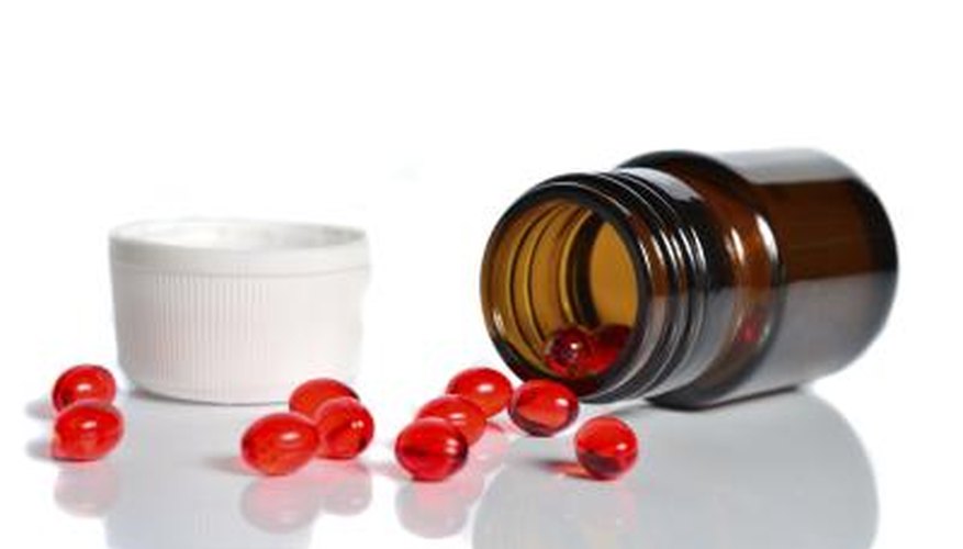 Jar spilling red pills onto tabletop. Jar spilling red pills onto tabletop.