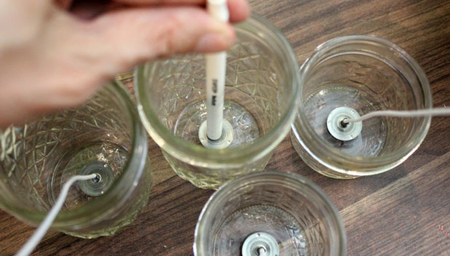 Place the wicks in the containers Place the wicks in the containers