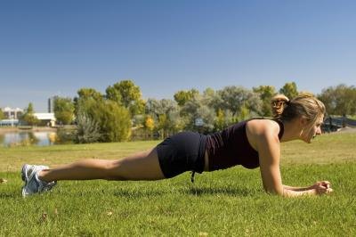 Woman holding the plank position outside.